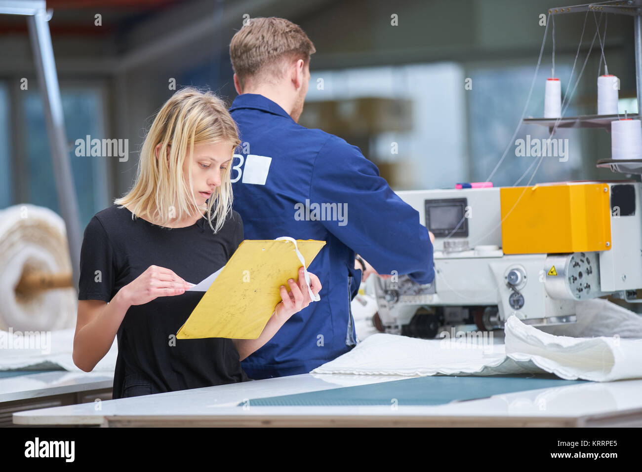 Costurera es asignado a una nueva máquina en una fábrica textil, el capataz explica algo Foto de stock