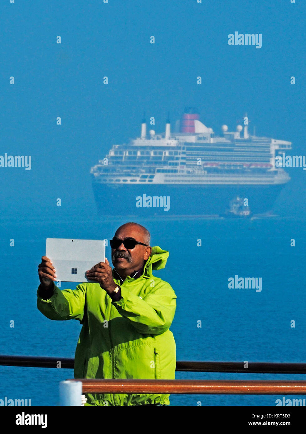 Pasajero de Celebrity Constellation haciendo selfie con Queen Mary 2 en el Canal de Suez. Foto de stock