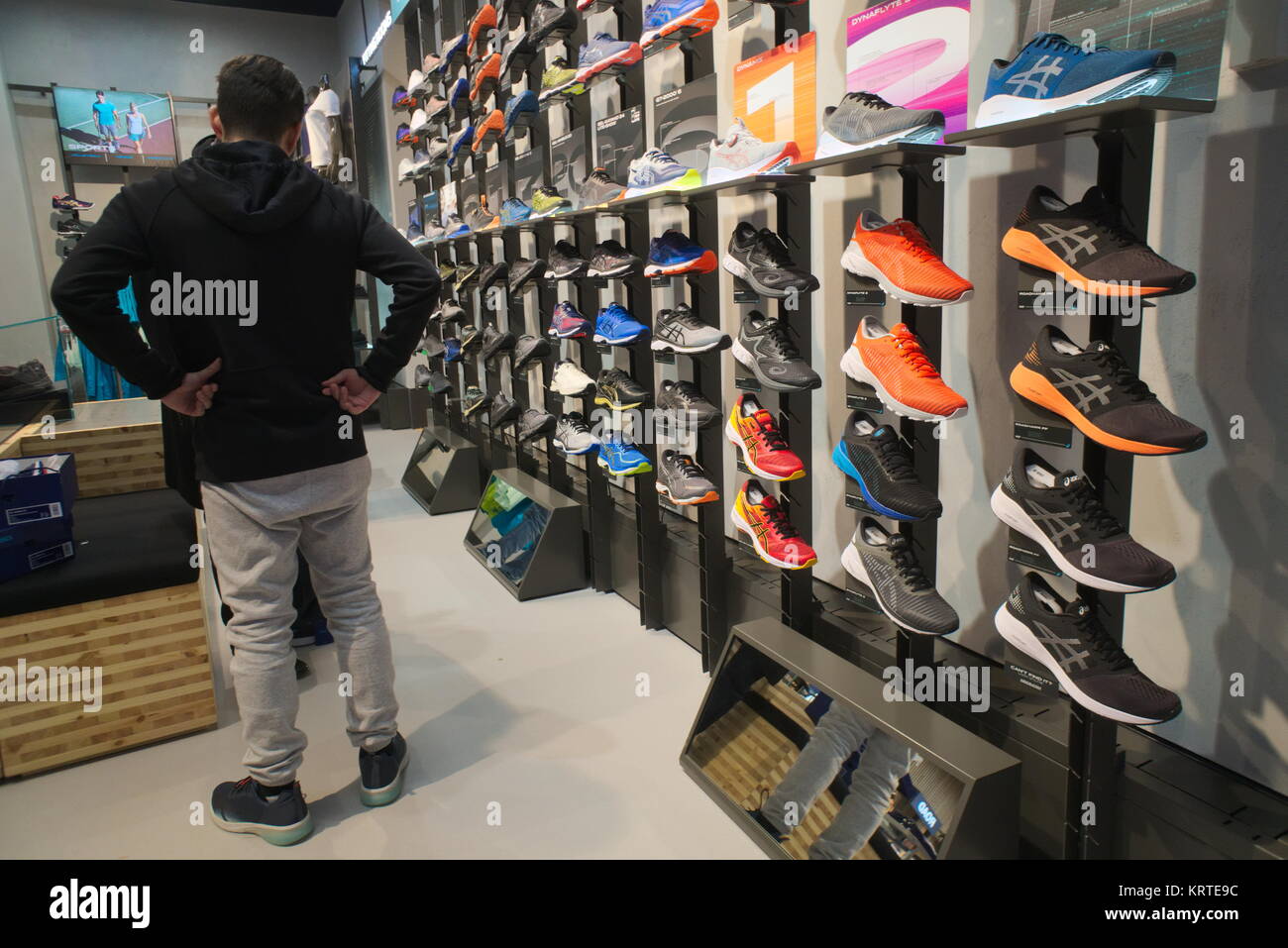 Los examinar el calzado en el recién Asics flagship store en la Quinta Avenida de Nueva York el viernes, 15 de diciembre de 2017.(© Richard B. Levine Fotografía de stock Alamy