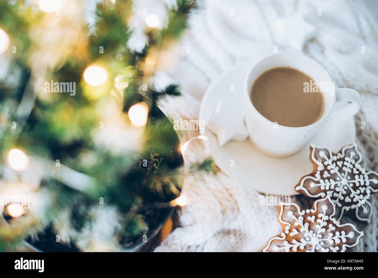 Acogedora casa decoración de navidad con una taza de café, pan de jengibre  y cobija tejida blanca, luces de año nuevo bokeh closeup Fotografía de  stock - Alamy