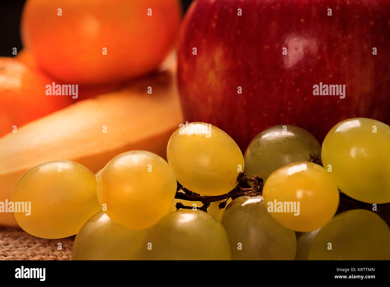 Nutrición orgánica frutos sanos alimentos. Amarillo Amarillo uvas con uvas, manzana roja y banana Foto de stock