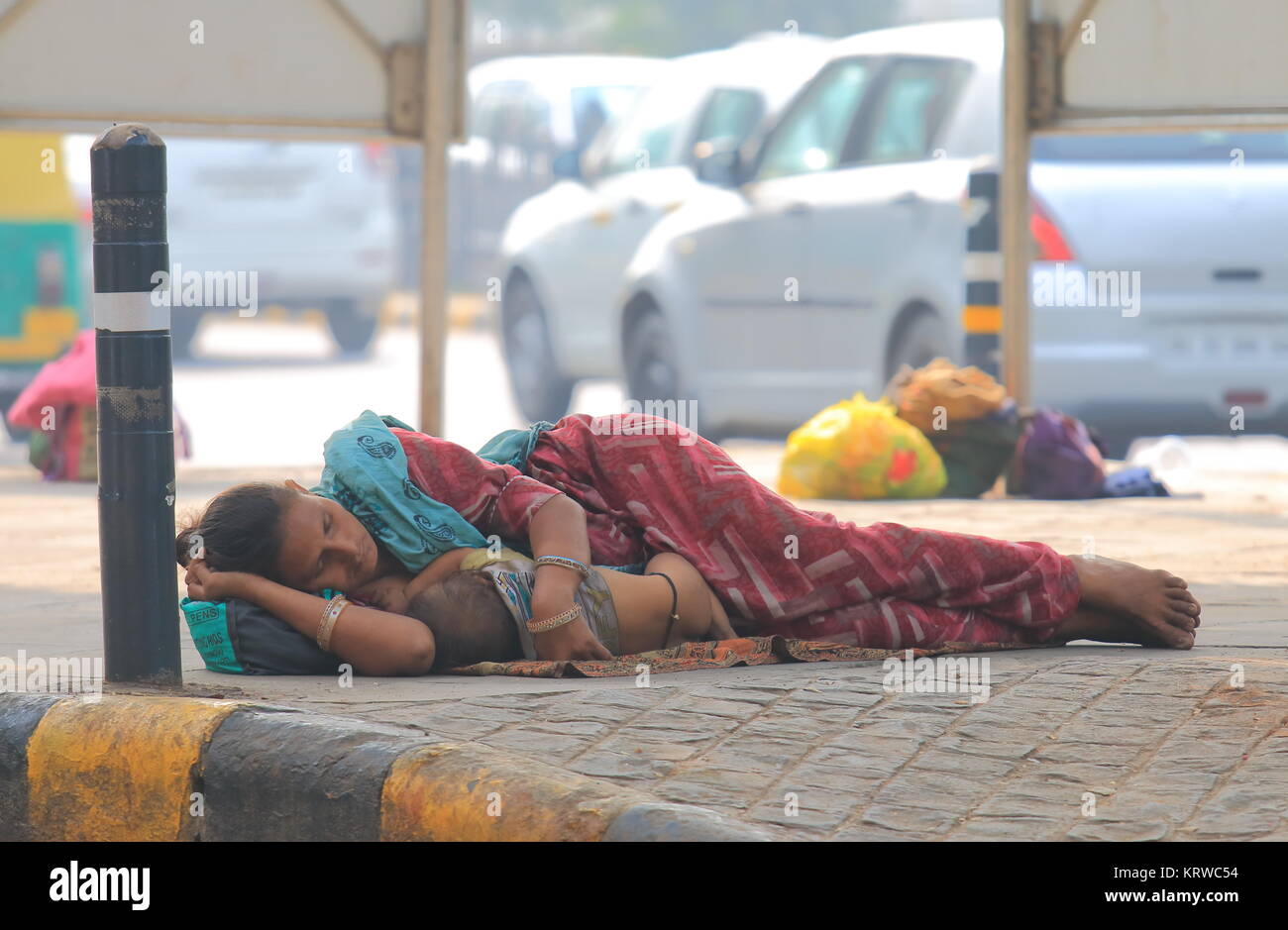 Mujer india abrace un bebé y duermen en la calle en el centro de Nueva Delhi, India Foto de stock