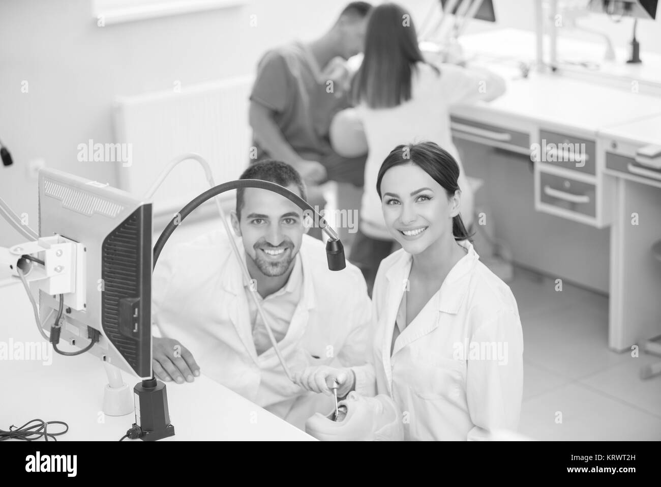 Dentaduras, higiene oral. Prótesis de manos mientras trabajaba en la dentadura, dientes postizos, un estudio y una mesa con herramientas dentales. Foto de stock