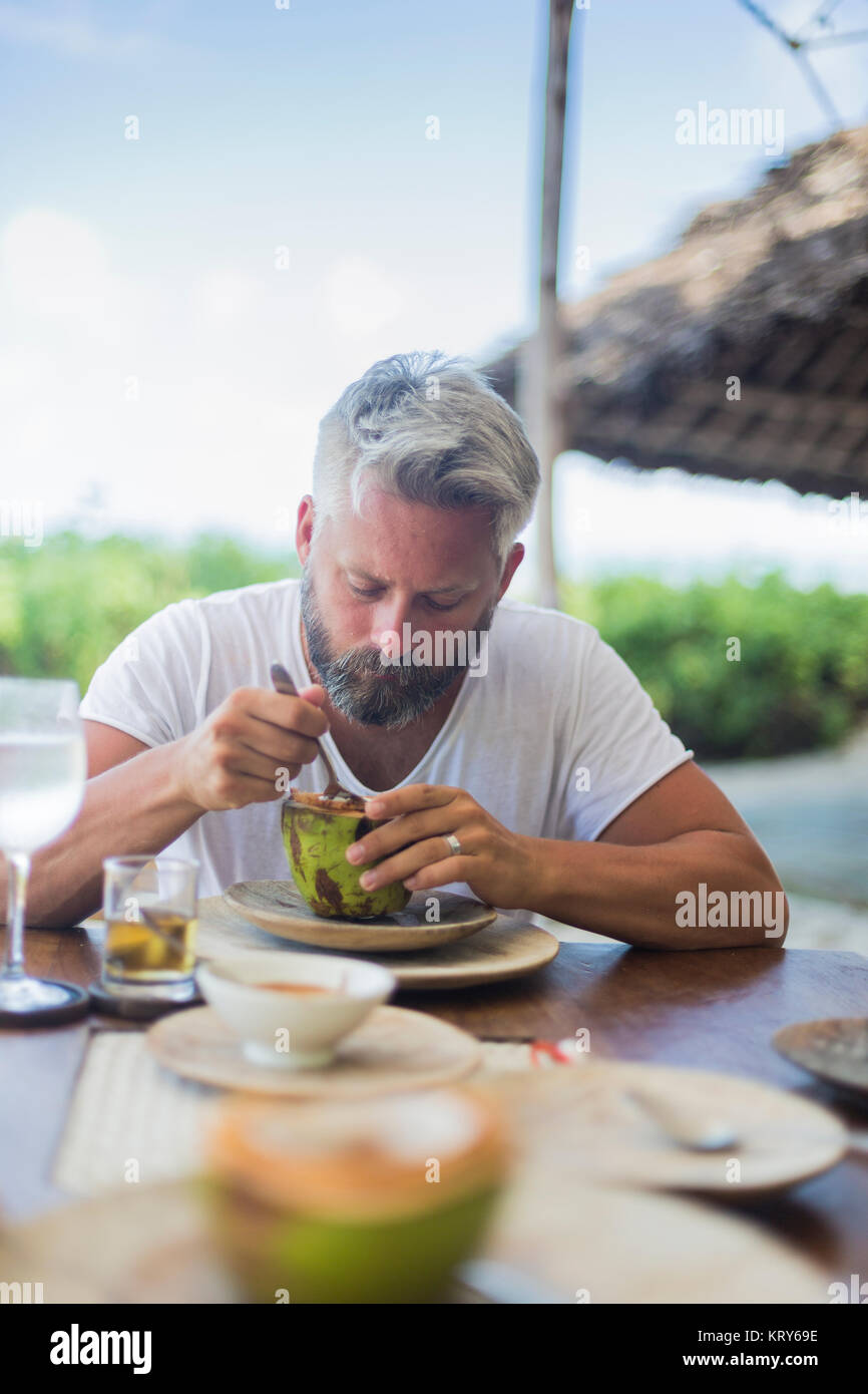 Mitad hombre adulto comiendo sandía en Diani Beach, Kenya Foto de stock
