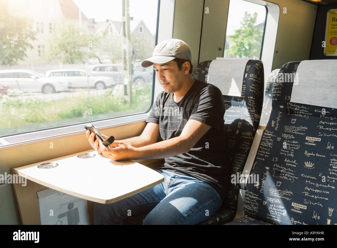 Hombre sujetando smart phone en tren Foto de stock
