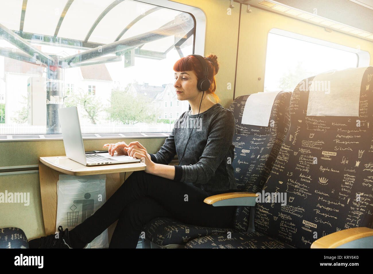 Mujer usando el portátil en el tren Foto de stock