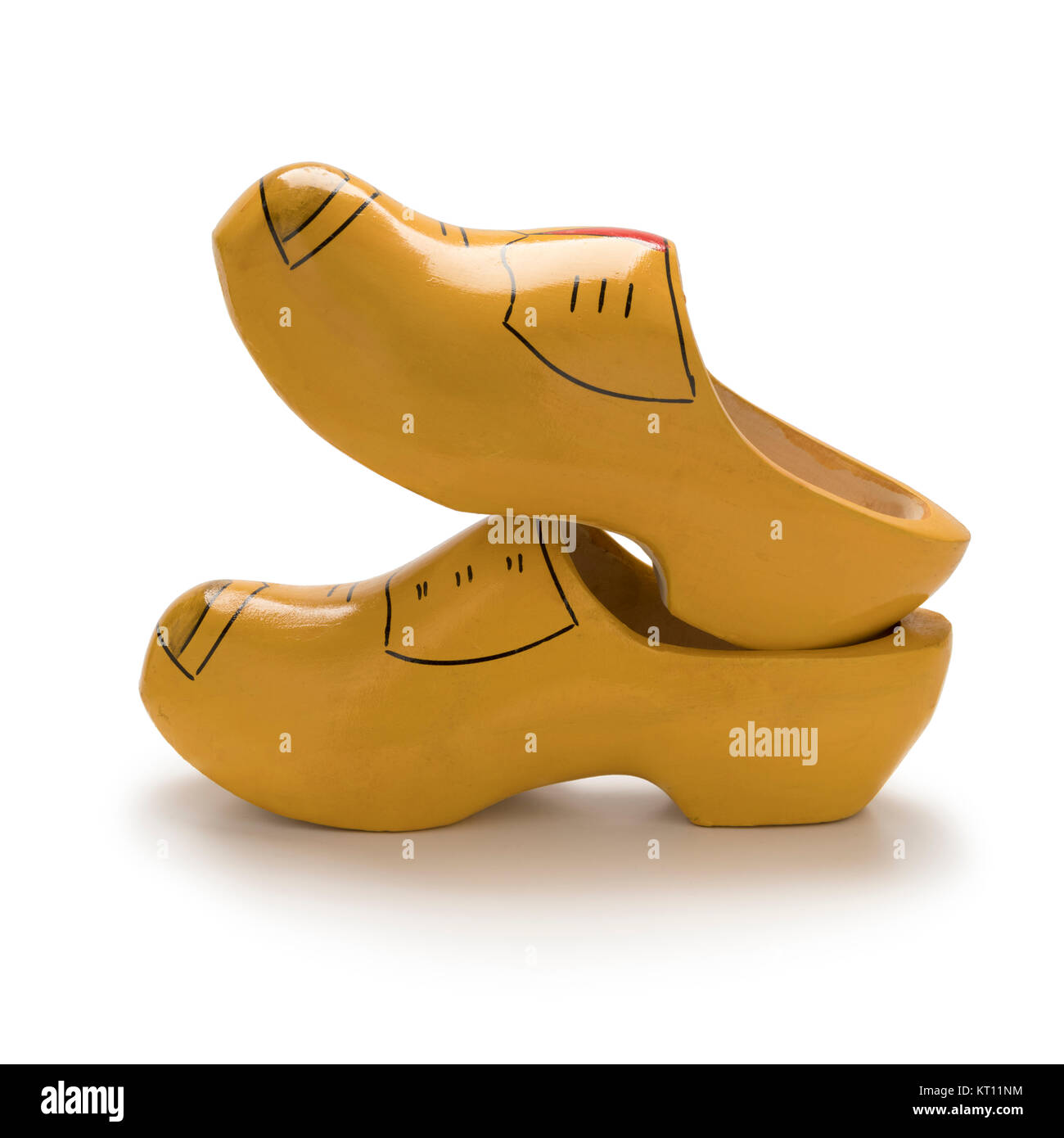 Zapatos de madera holandés tradicional amarillo sobre fondo blanco. Foto de stock