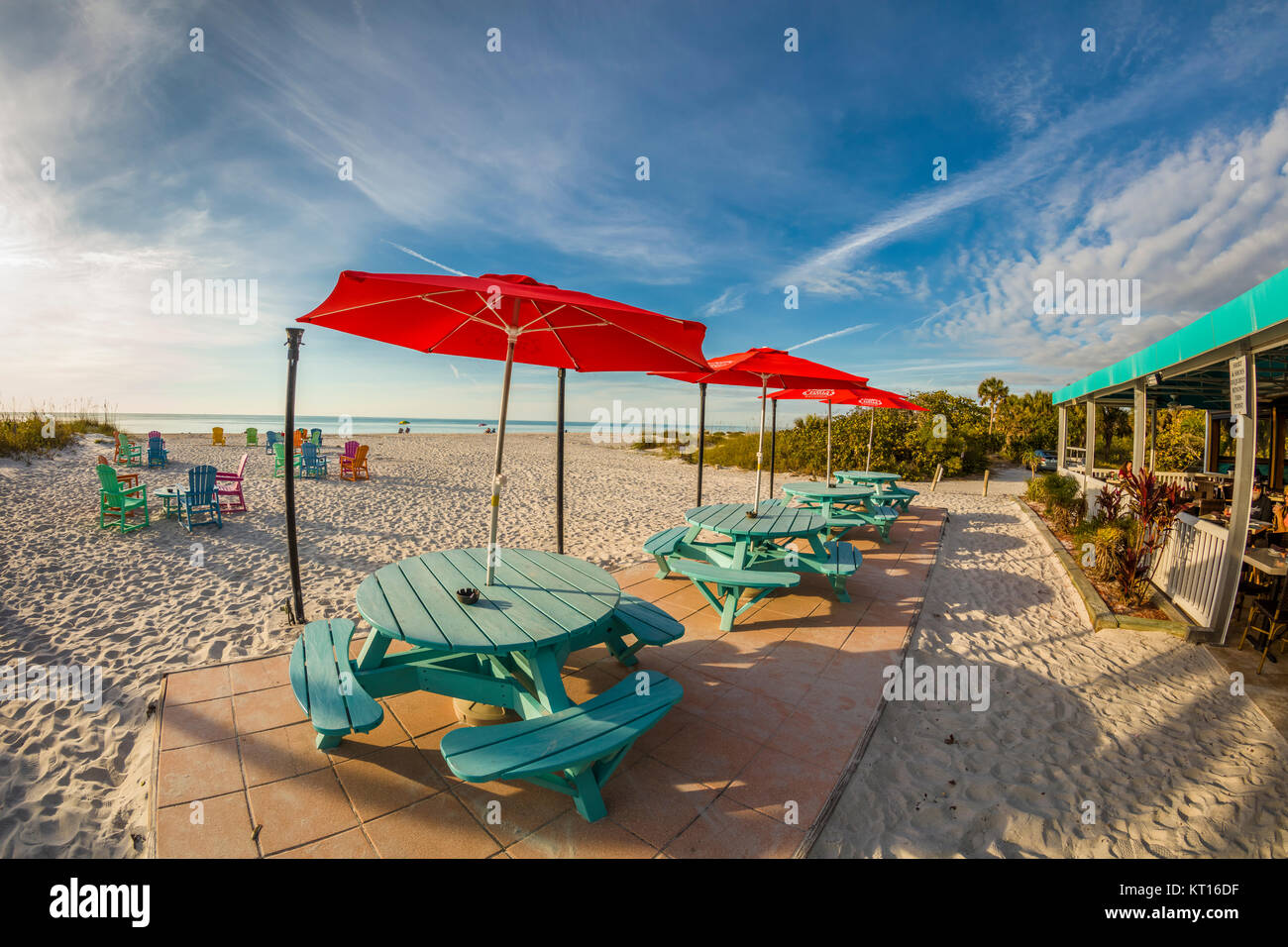 Mesas de picnic y sillas en la playa en un día soleado en el South Beach Bar & Grill en Florida Isla Gasparilla Foto de stock