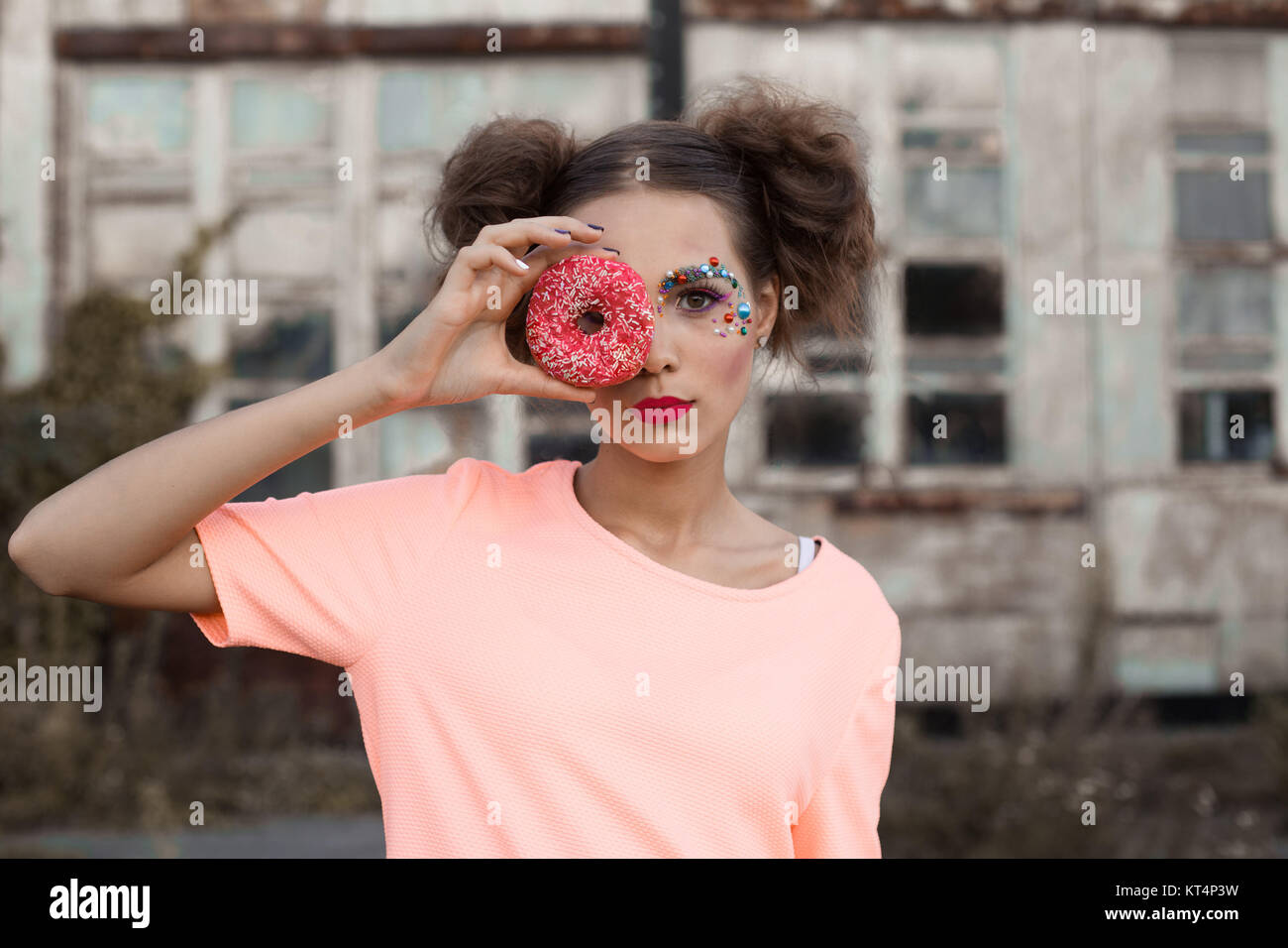 Close Up retrato de mujer joven que cubre sus ojos con donuts sobre fondo  blanco.belleza moda chica modelo tomar dulces y coloridas donuts.gracioso  alegre estilo de moda mujer con dulces Fotografía de