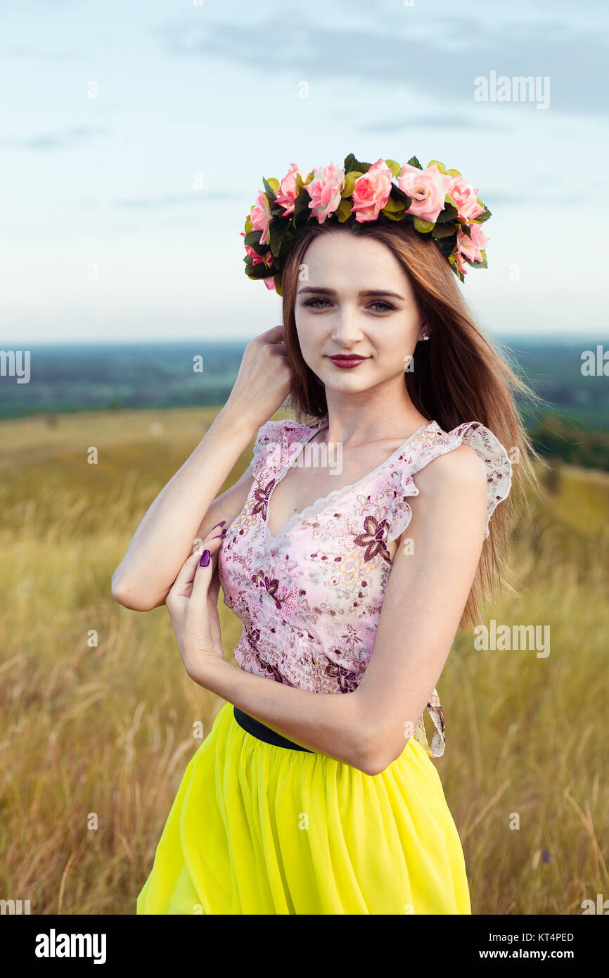 Hermosa Hermosa niña bonita moda en vestidos en el campo de flores. Linda chica con corona de flores en la cabeza y ramo de muchas flores amarillas sentado en pradera campo amarillo Hermosa Hermosa niña bonita moda en vestidos en el campo de flores. Linda chica con corona de flores en la cabeza y ramo de muchas flores amarillas sentado en pradera campo amarillo