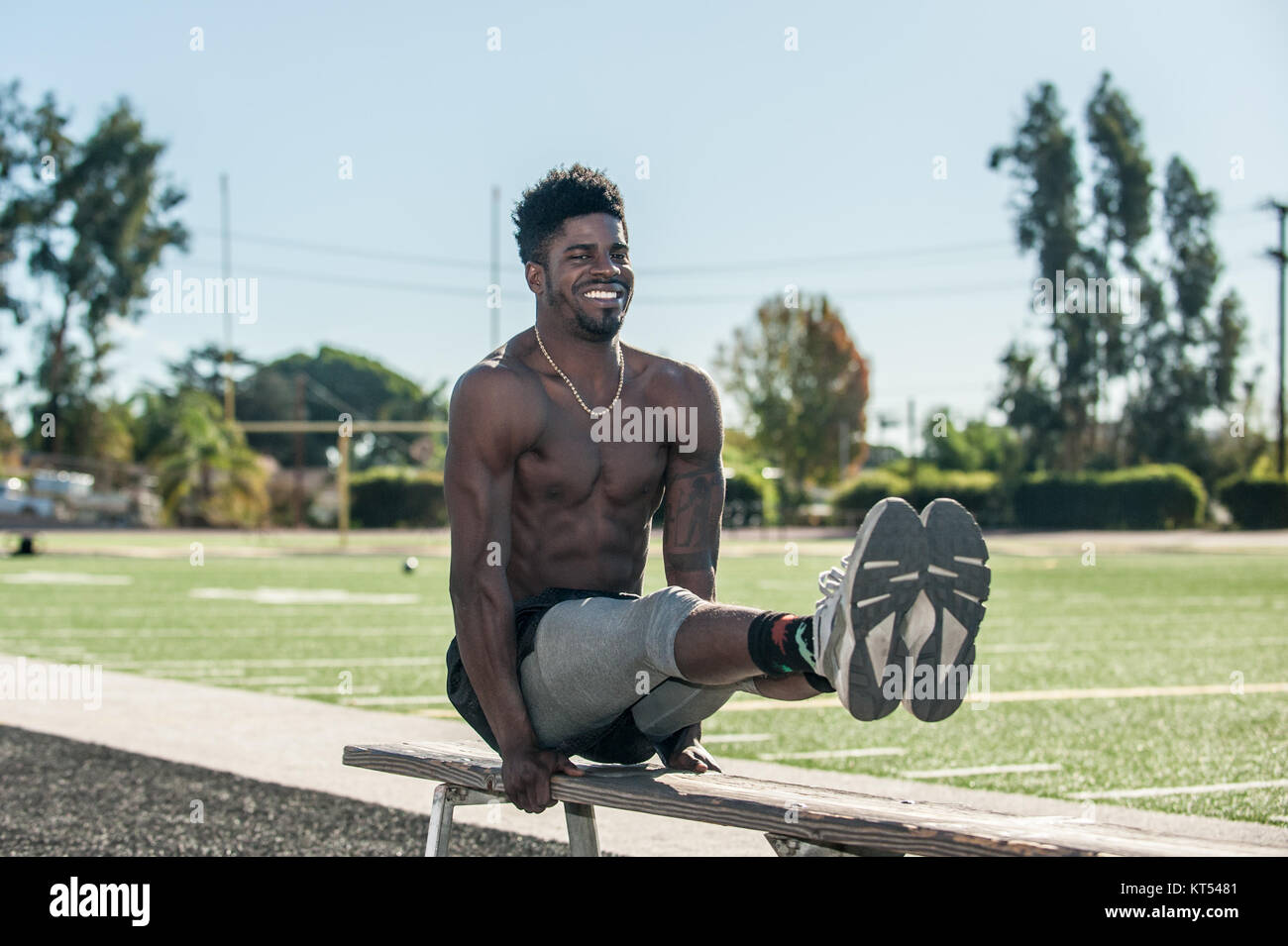 Musculoso atleta jamaiquino realizar elevación de la pierna en el banco con  la abultada tríceps en el estadio Fotografía de stock - Alamy