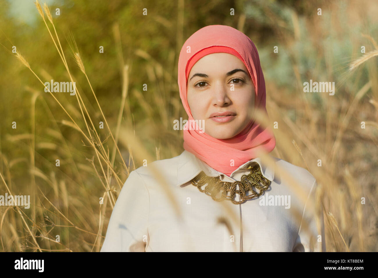 Hermosa mujer musulmana de pie en el campo Foto de stock