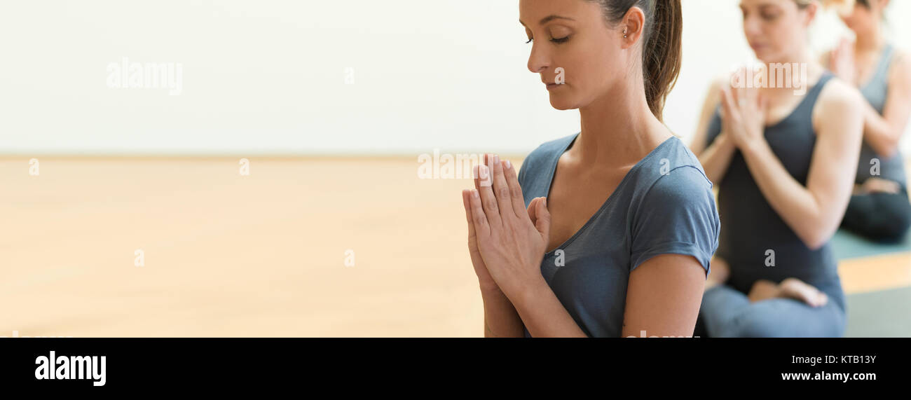 Las mujeres que practican yoga y meditación de atención plena juntos, estrechando manos y relajante, la vida sana y el concepto de espiritualidad Foto de stock