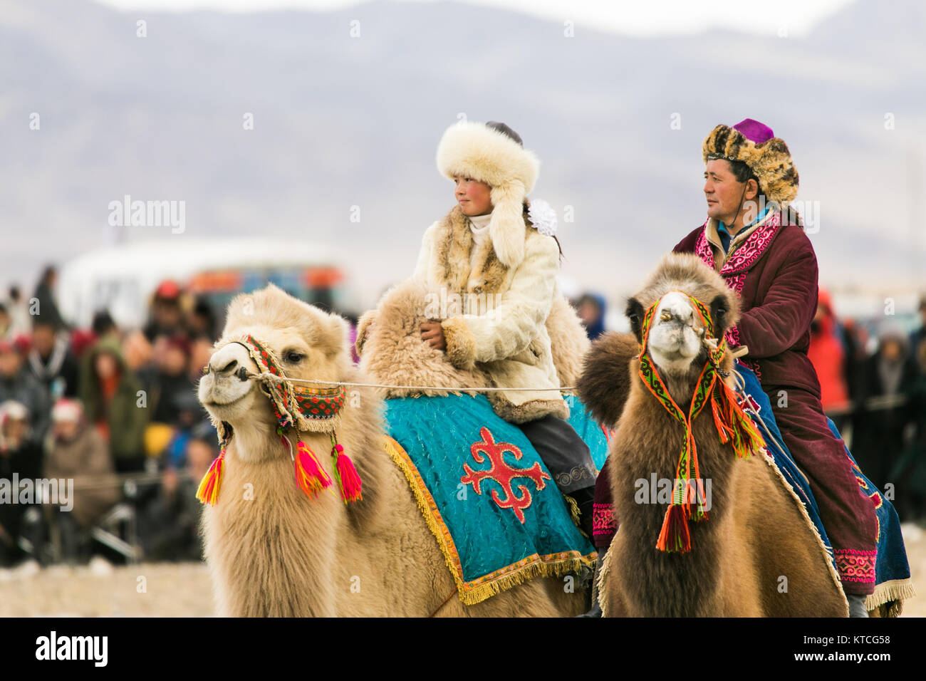 Aisholpan el Águila cazadora y otro jinete de camellos en el Festival Golden Eagle en Mongolia Foto de stock
