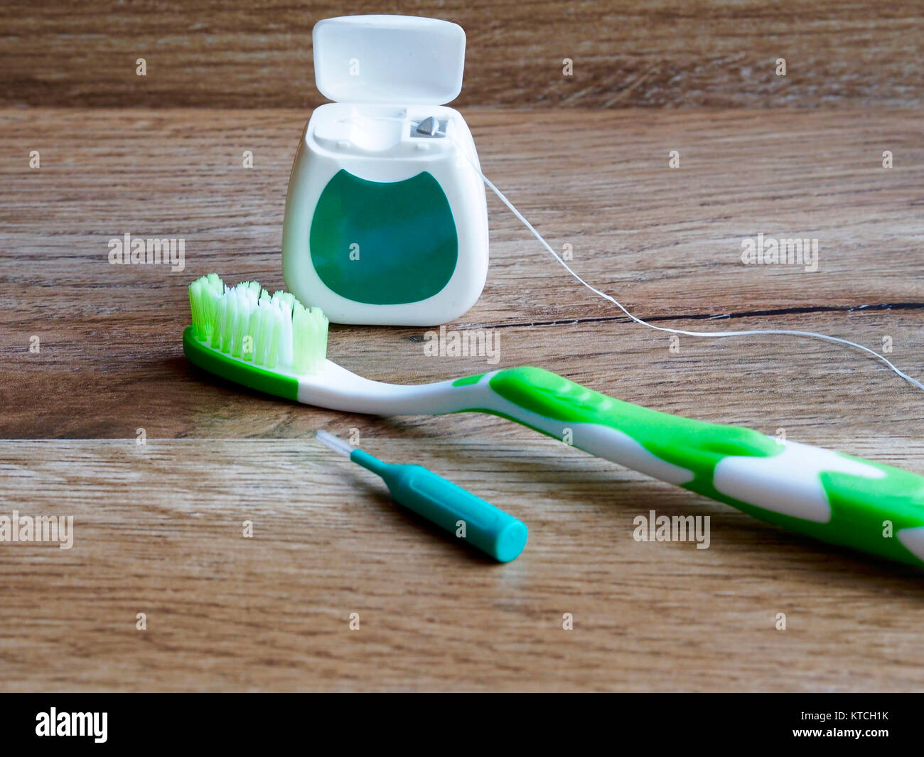 El hilo dental, cepillo de dientes y cepillo interdental sobre fondo de  madera Fotografía de stock - Alamy