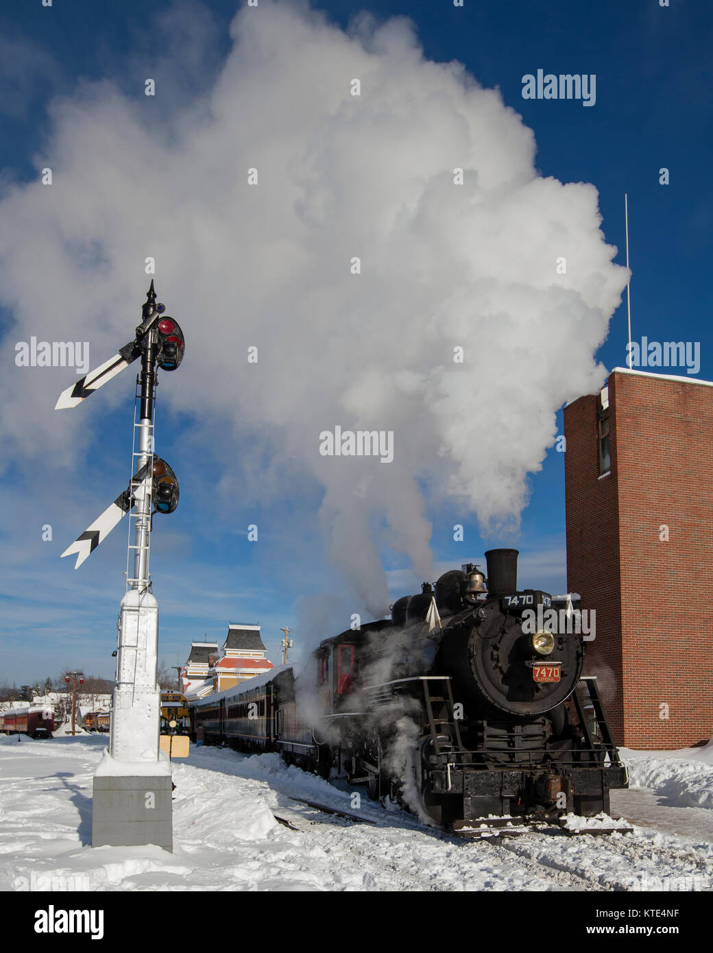 Motor a vapor en la nieve con señal de ferrocarril Foto de stock