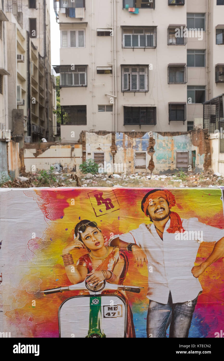 Póster de Bollywood en pared con edificios de apartamentos, en el fondo, Bangalore, Karnataka, India. Foto de stock