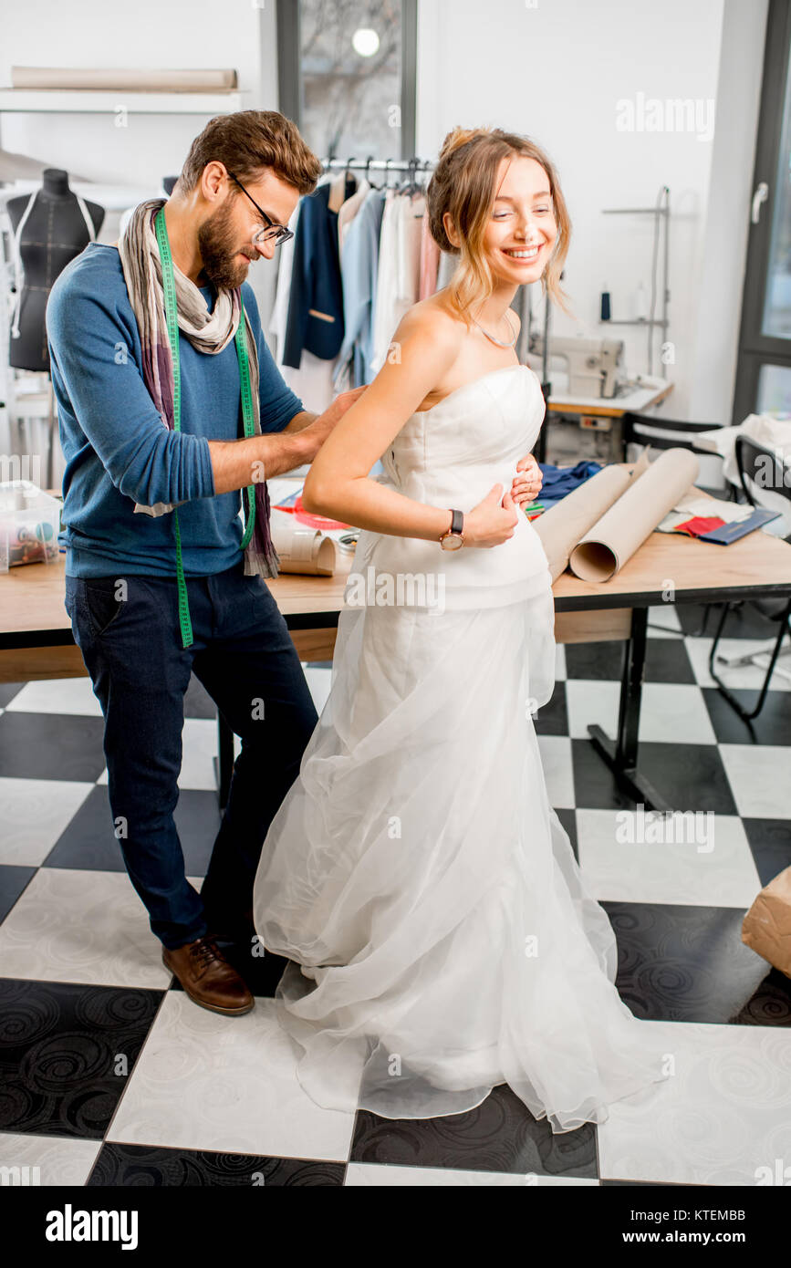 Escultura Desenmarañar Izar Adaptador de cliente joven vestido de novia con el hombre sastre coser  permanente en la studio Fotografía de stock - Alamy
