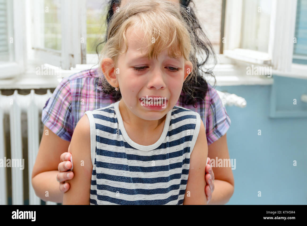 Niño de edad preescolar es llorar después de que ella ha recibido vacuna inyectable en el consultorio médico. Foto de stock
