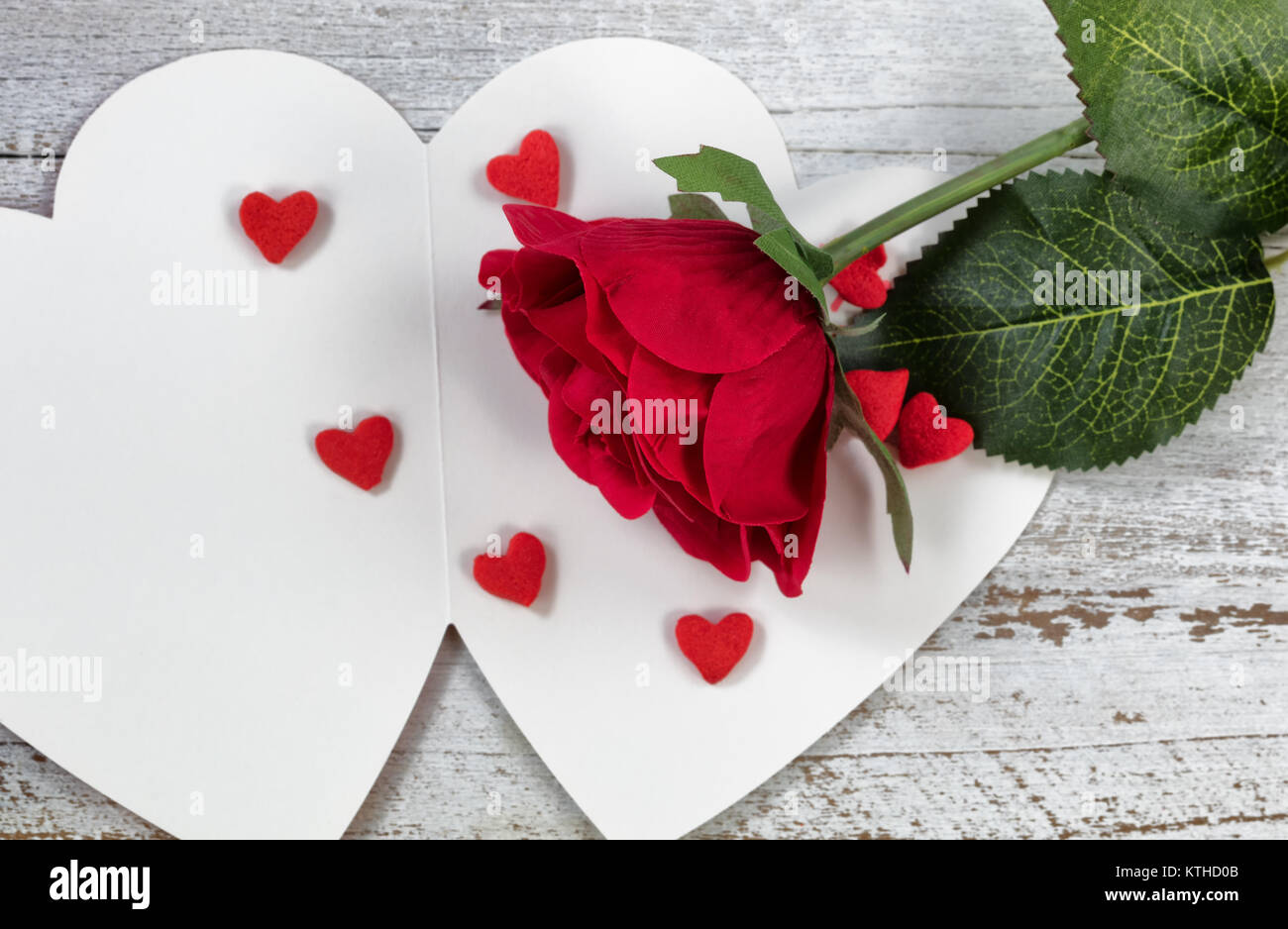 Tarjeta de San Valentín con una rosa roja y pequeñas formas de corazón Foto de stock