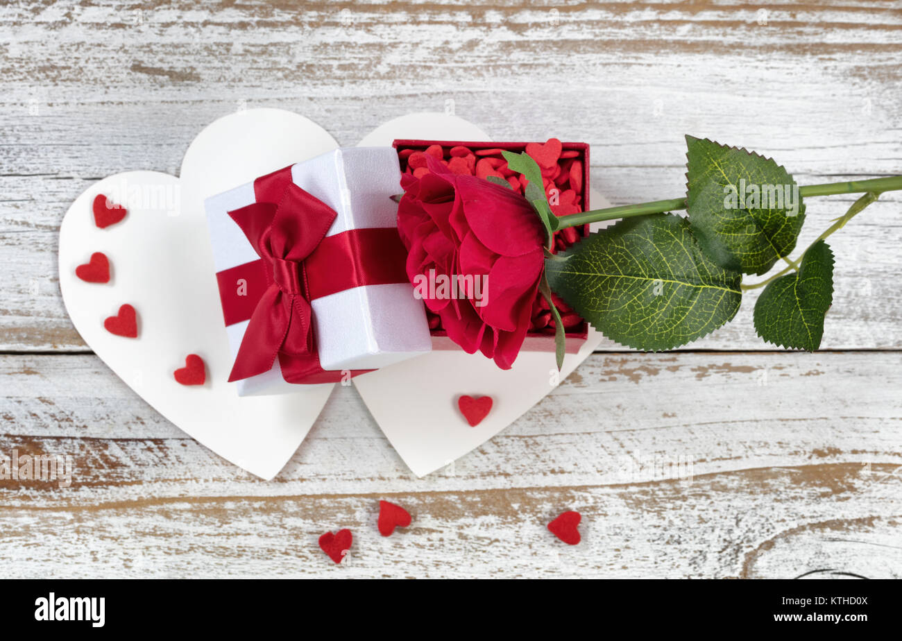 Tarjeta de San Valentín con Abrir caja de regalo y una rosa roja en rústico de madera blanca Foto de stock