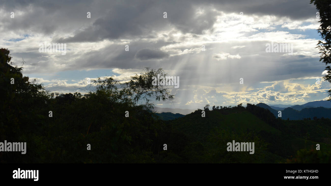 Hermoso paisaje de montaña con sol brillando a través de las nubes en el cielo en Laos - Asia Foto de stock