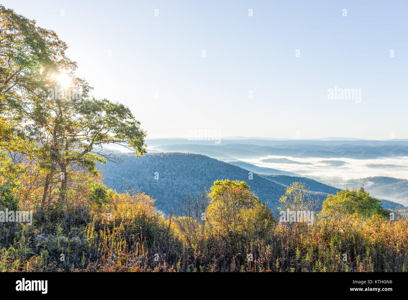Vistas de las montañas de West Virginia en otoño caen con follaje y niebla y nubes de niebla cubriendo valle en amanecer solar, sunburst glade Foto de stock