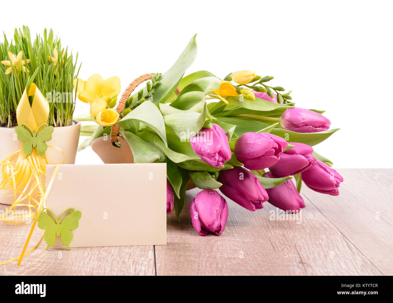 Primavera arreglos florales y una tarjeta de felicitación en una mesa de  madera contra la pared blanca, espacio de texto Fotografía de stock - Alamy