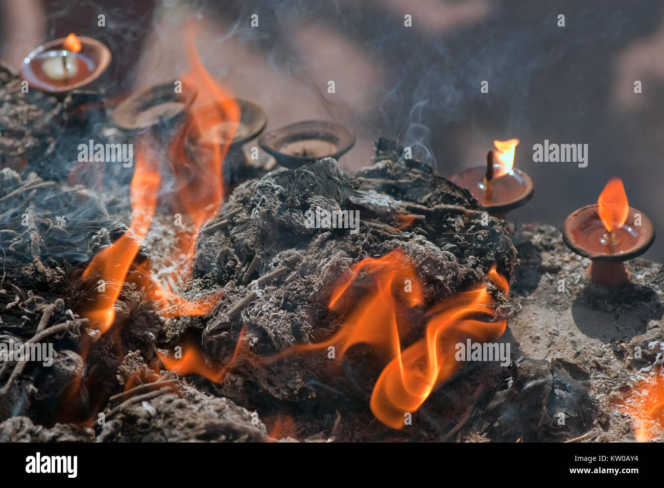 Velas de aceite hindú entre los reproches y las cenizas con el fuego, Nepal. Foto de stock