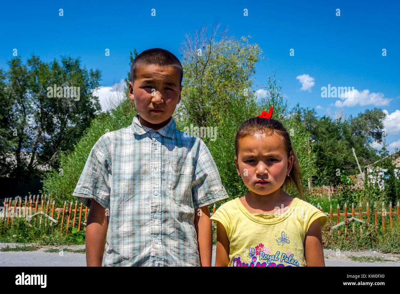 UGUT, Kirguistán - Agosto 16: hermanos, un hermano y una hermana posando con grave expresión facial. Ugut es una remota aldea en Kirguistán. Agosto 201 Foto de stock