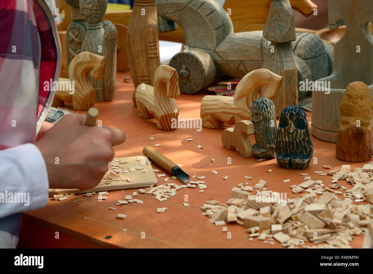San Petersburgo, Rusia - Mayo 22, 2016: Master Class de talla de madera en un contador con self-made juguetes de madera en estilo nacional en una feria Foto de stock