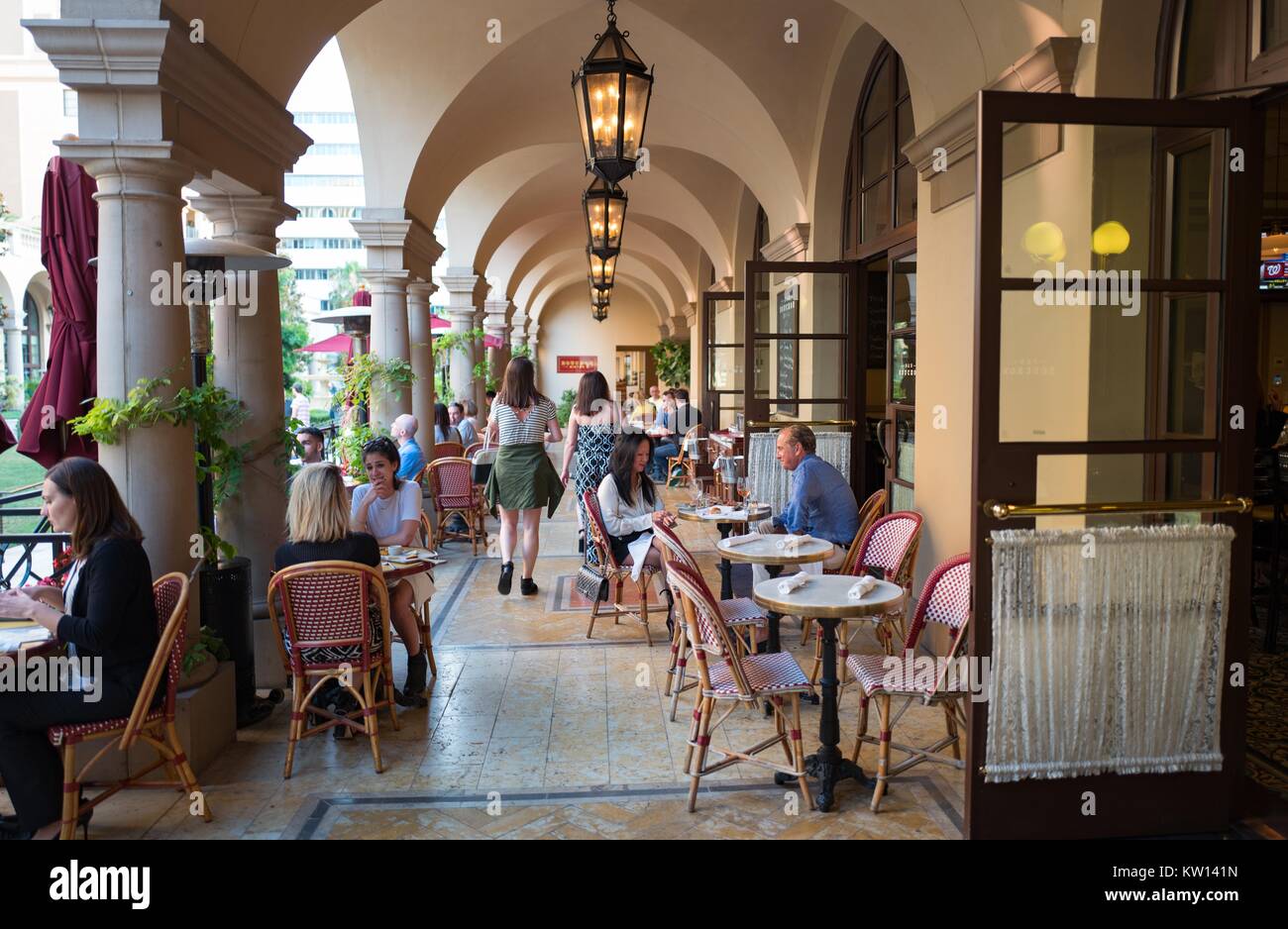 En el patio del Bar Bouchon, parte de los Bouchon de estilo bistro restaurante gestionado por el chef Thomas Keller, diners hablar y disfrutar de sus comidas, Beverly Hills, Los Ángeles, California, en 2016. Foto de stock