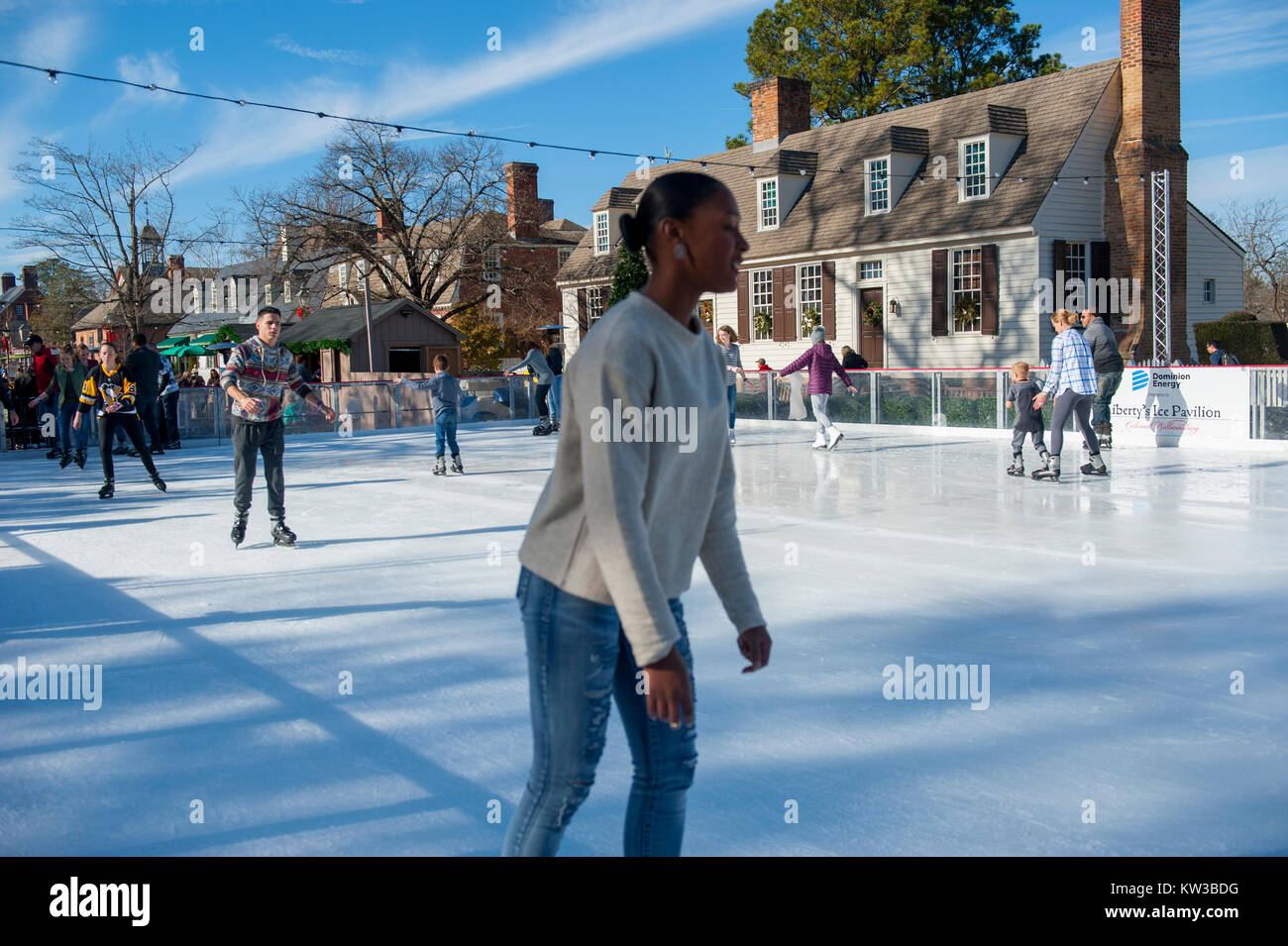 Ee.Uu. Virginia Colonial Williamsburg VA Navidad invierno patinar sobre hielo en una pequeña pista de patinaje en el Duque de Gloucester Street durante la temporada de vacaciones Foto de stock