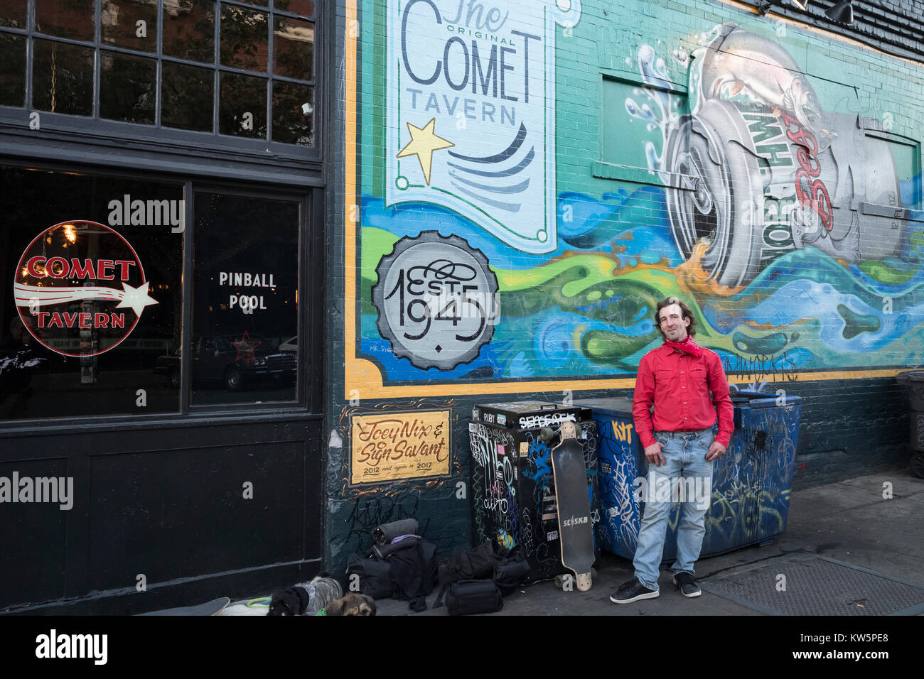 Un amigo delante de un cartel para el Comet Tavern en Capitol Hill, en Seattle, Washington, EE.UU. Foto de stock