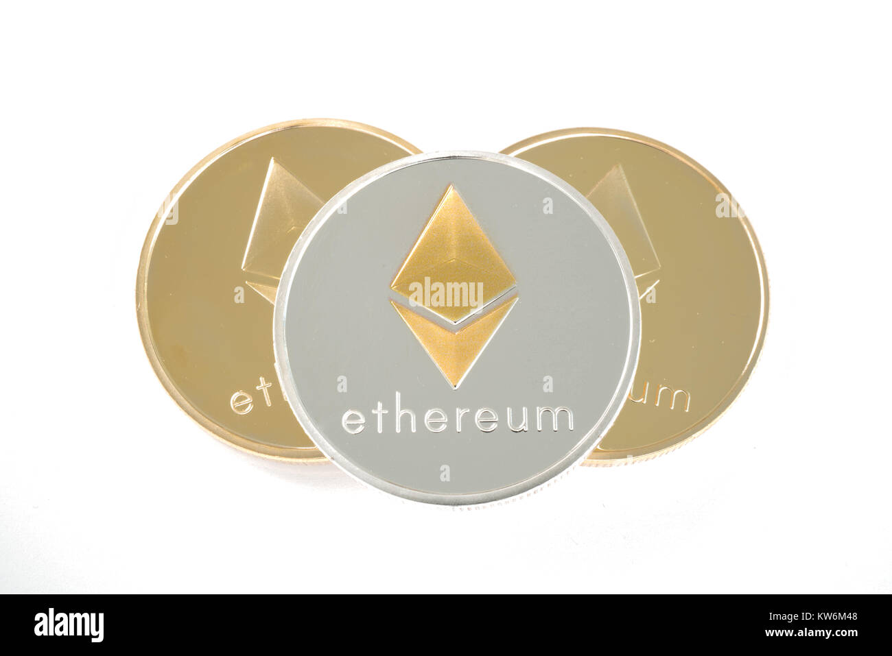 Tres verdaderas monedas de oro y plata cryptocurrency Ethereum aislado sobre fondo blanco. Foto de stock
