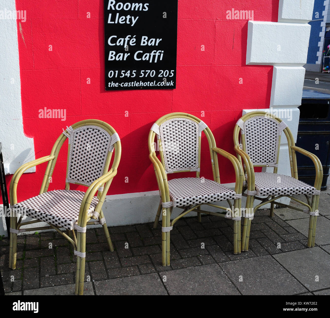 Tres sillas tejidas fuera un hotel Cafe, Aberaeron, Ceredigion, Gales. Foto de stock