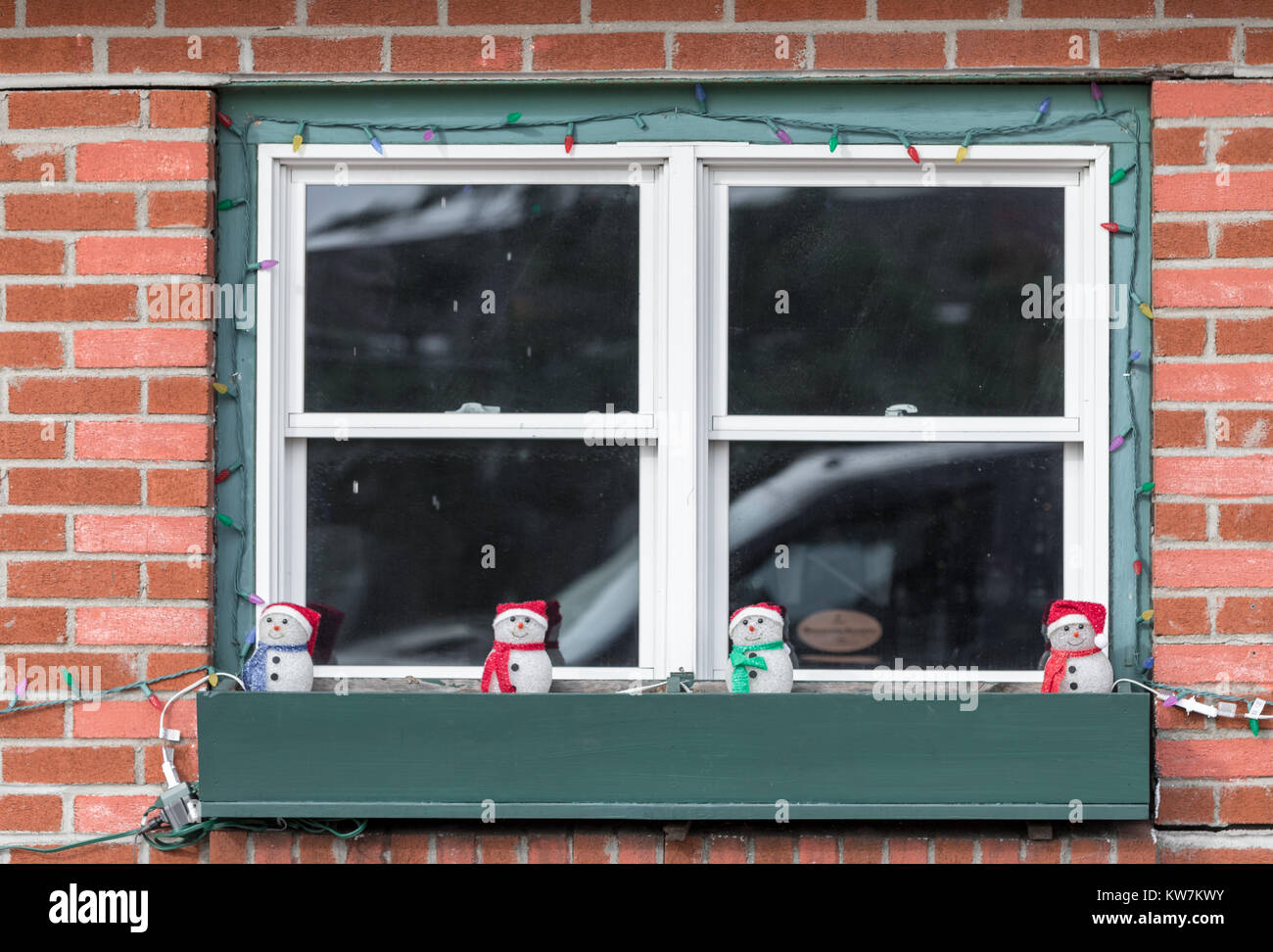 La calle de Navidad adornos en una ventana de verificación delante de una ventana. Foto de stock