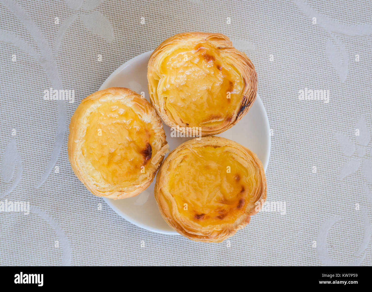 Tres portugueses Flan tartas en una placa Foto de stock