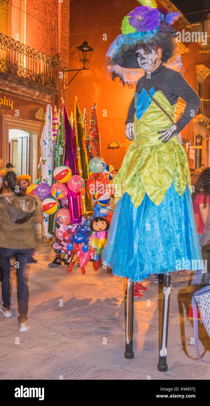 Hombre en un colorido traje y sombrero, sobre zancos;festiva de disfraces y  máscaras para las festividades del Día de los muertos, en las calles de San  Miguel de Allende Fotografía de stock -