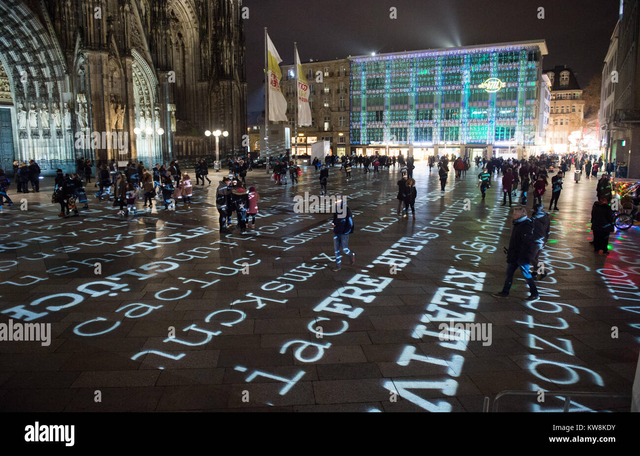 Colonia, Alemania. 30 dic, 2017. Las palabras y letras se proyectan en la  Domplatte (la plaza de la catedral), como parte de una instalación de luz  por el artista Ingo Dietzel en