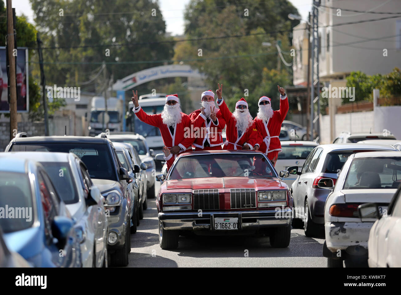 La ciudad de Gaza, FRANJA DE GAZA, Territorio Palestino. 31 dic, 2017. Los  palestinos vestidos como Santa Claus ride un coche rojo para dar la  bienvenida al nuevo año, en las calles