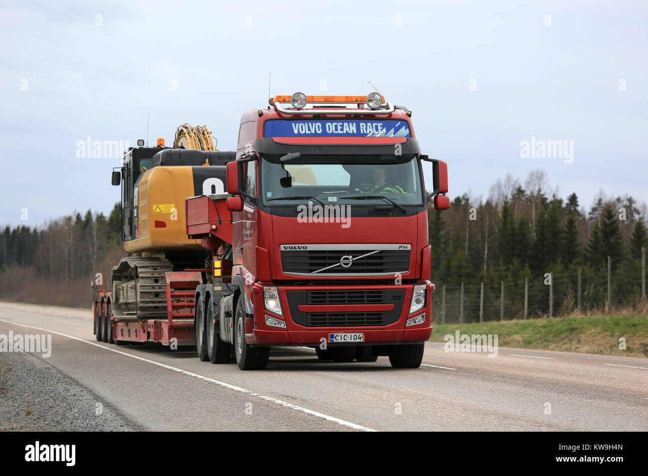 ORIVESI, Finlandia - 17 de mayo de 2017: Volvo FH semi lances Cat 336FL gran hidráulica Excavadora de oruga sobre remolque cuello de ganso junto a la autopista en primavera. Foto de stock