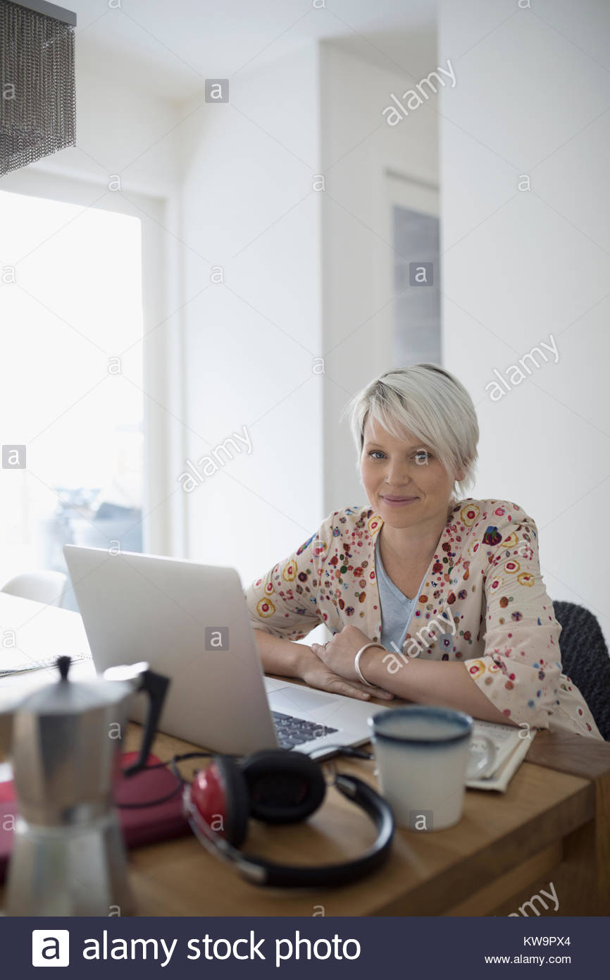 Retrato mujer confiada teletrabajo,trabajando en el portátil en la mesa de comedor Foto de stock