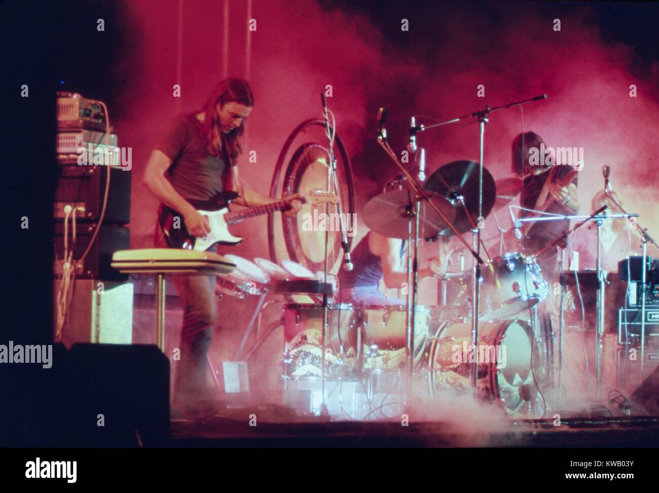 Pink Floyd tocando en el escenario, rodeados con un humo y un rojo iluminado con luces del escenario durante el concierto a Merriweather Post Pavilion, Columbia, Maryland, en junio de 1973, julio de 1973. Imagen cortesía de los Archivos Nacionales. () Foto de stock