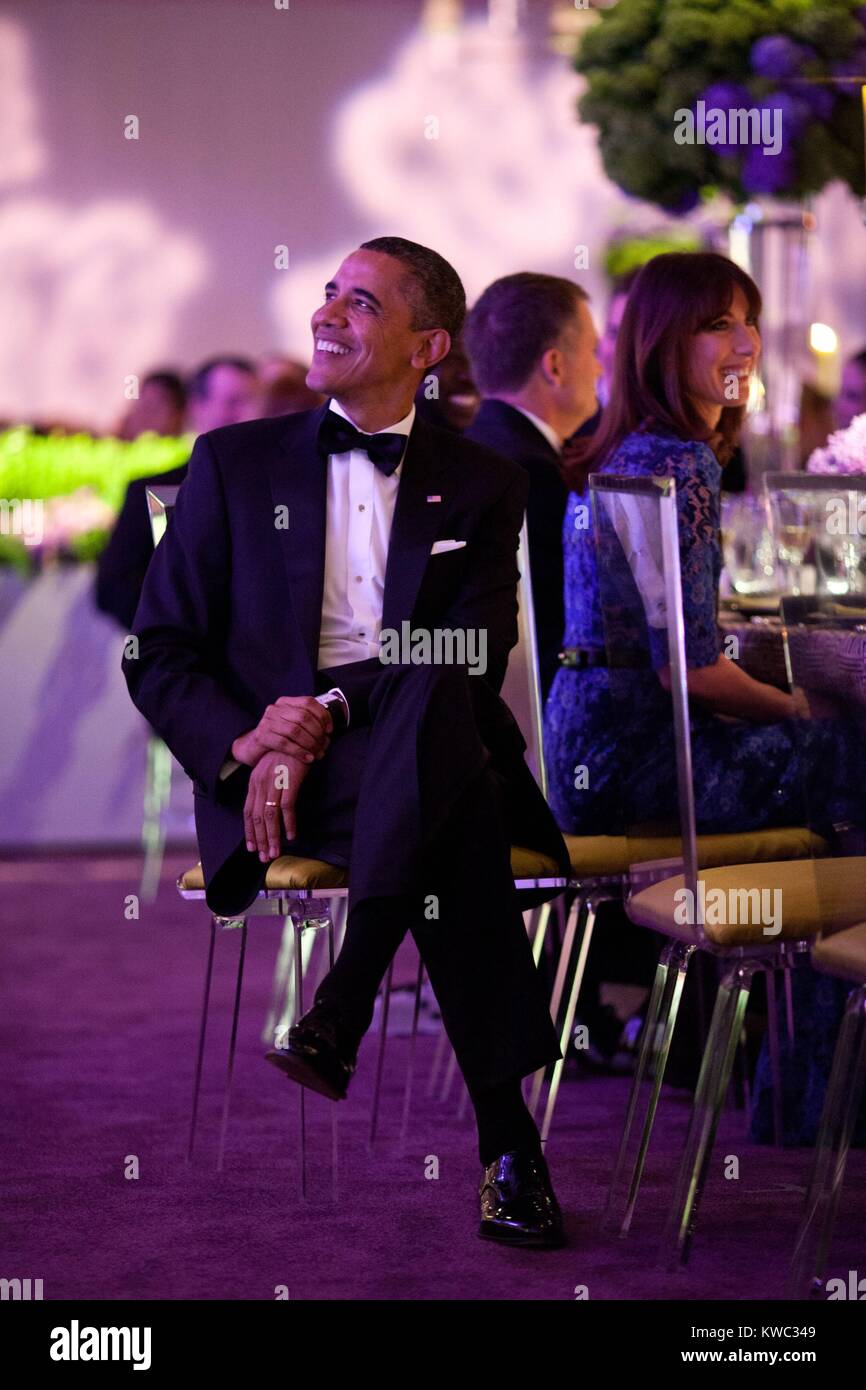 El presidente Barack Obama escucha al Primer Ministro Británico David Cameron en la Cena de Estado. Samantha Cameron está sentado a la derecha. Jardín Sur de la Casa Blanca, 14 de marzo de 2012. (BSLOC 2015 13 208) Foto de stock
