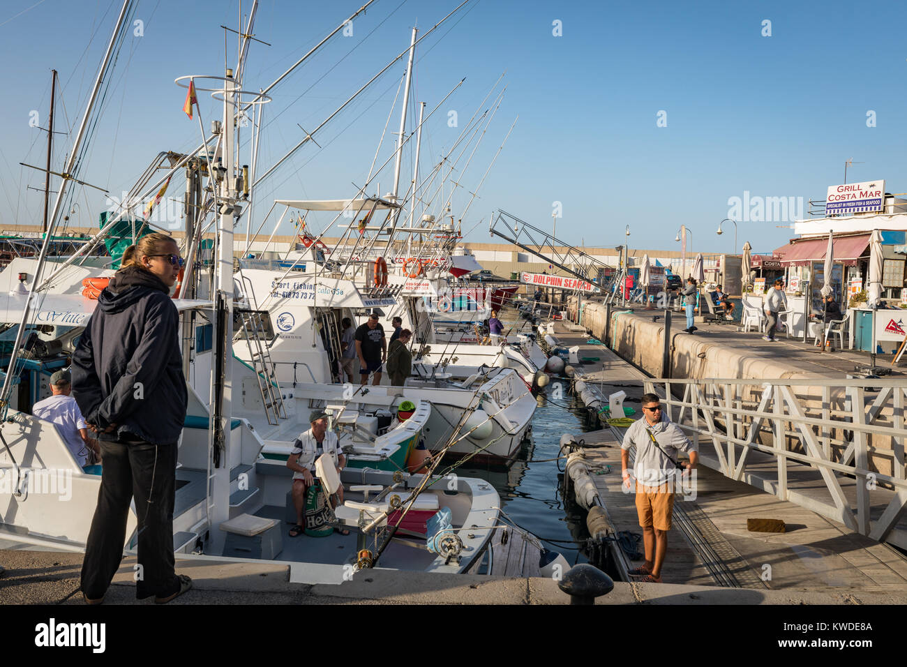 Puerto Rico, Gran Canaria - 12 de diciembre de 2017: la Marina de Puerto Rico, los turistas van en excursiones en barco de pesca en la mañana. Muchas empresas ofrecen excursiones en barco para practicar la pesca y el turismo. Foto de stock