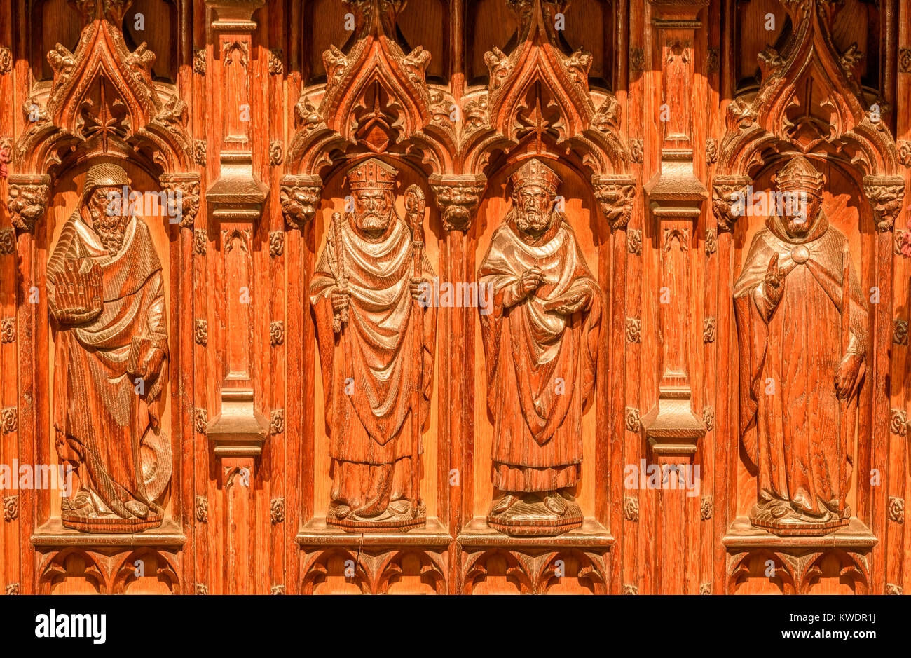 Tallas de la silla de madera del obispo en el coro de la catedral cristiana  construida por los conquistadores normandos en el siglo XI en el Lincoln,  Engla Fotografía de stock -