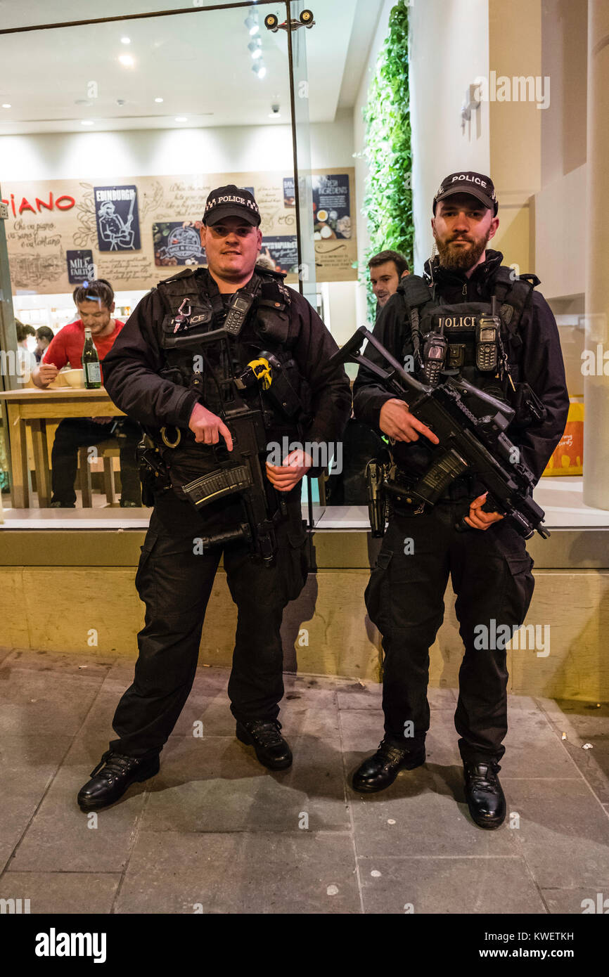 Policías fuertemente armados de guardia en Edimburgo Hogmanay street party en la víspera de Año Nuevo en Escocia, Reino Unido Foto de stock