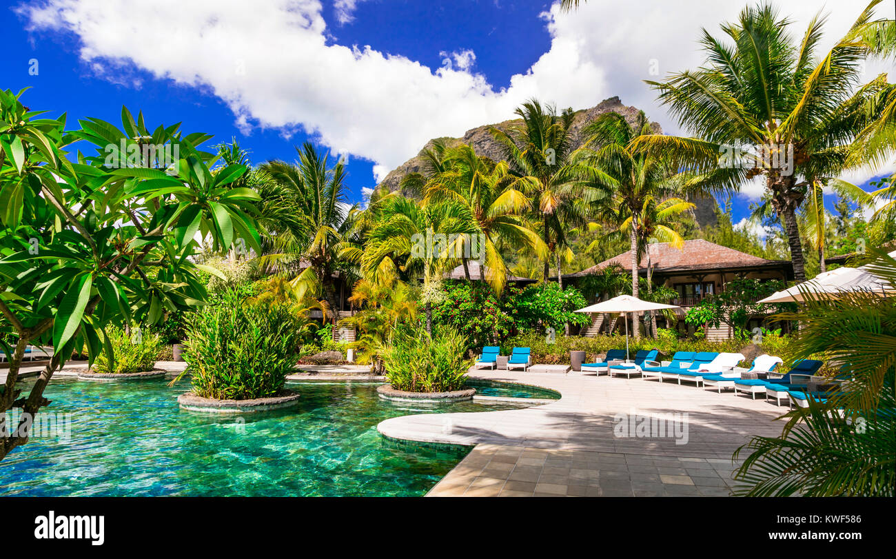 Relájese en Tropical Le Morne, Isla Mauricio,ver con piscina,palmera y bungalows. Foto de stock