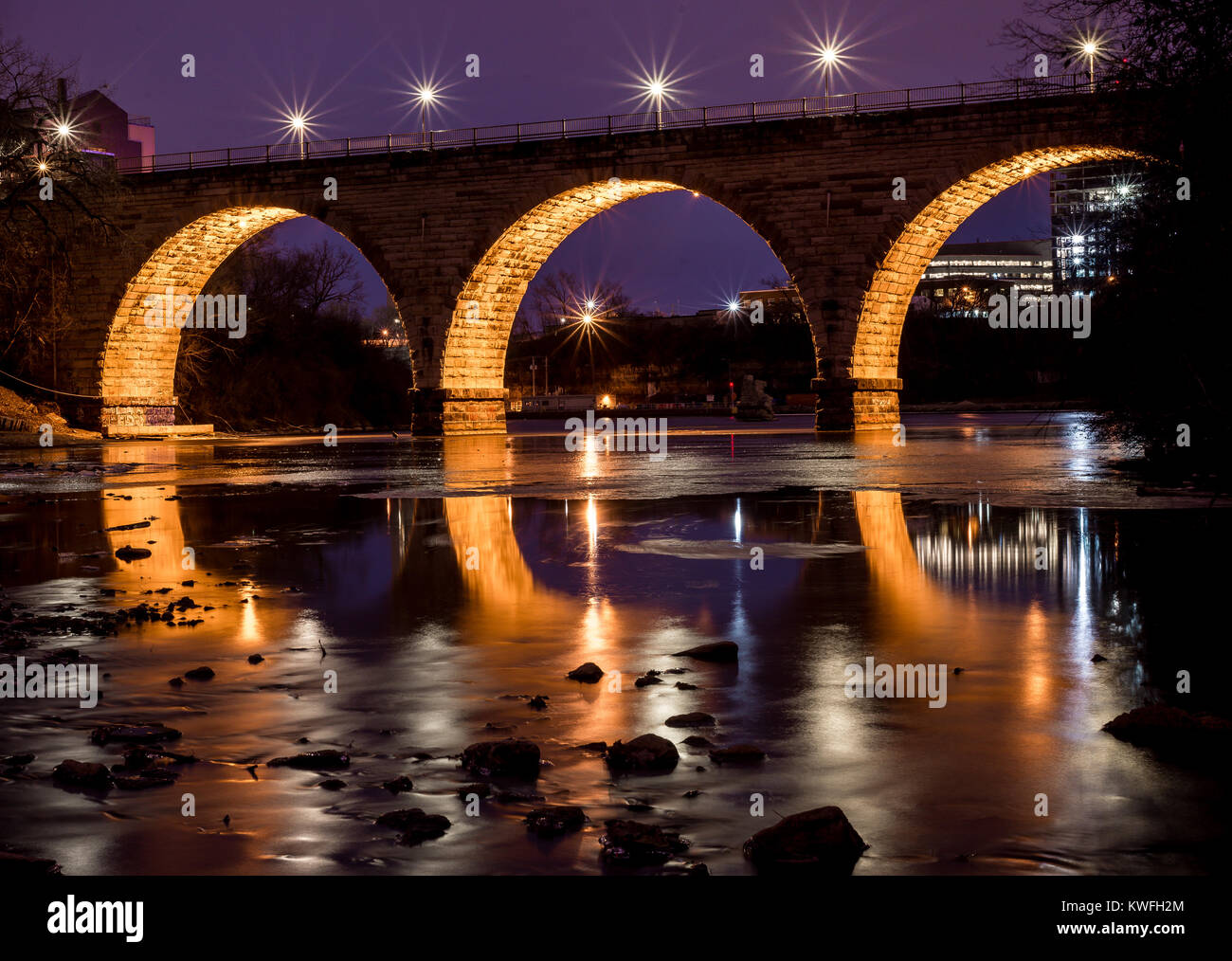 Exposición larga noche azul crepúsculo hora tiro de piedra del Arco del puente de Minneapolis, Minnesota, a orillas del río Mississippi Foto de stock